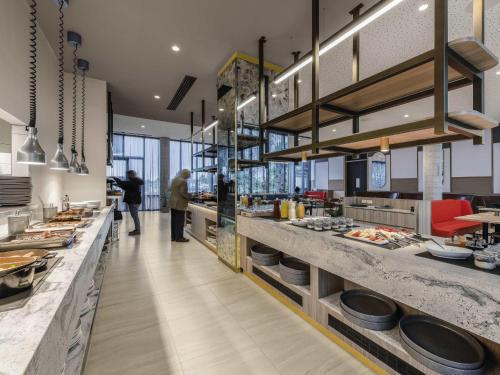 a restaurant with a long counter with people in it at Mantra Melbourne Epping in Epping