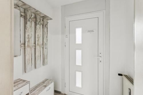 einen weißen Flur mit Tür und Fenster in der Unterkunft Büchner 52-1 in Gera