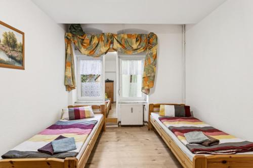 zwei Betten in einem Zimmer mit zwei Fenstern in der Unterkunft Büchner 52-1 in Gera