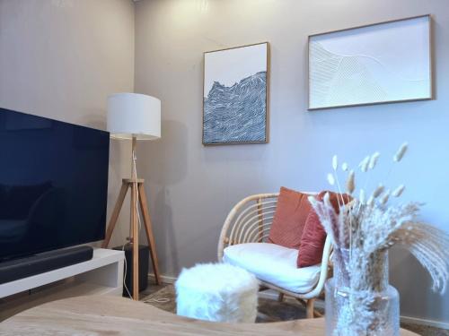 a living room with a chair and a tv at Coastal Guest House in Rauma