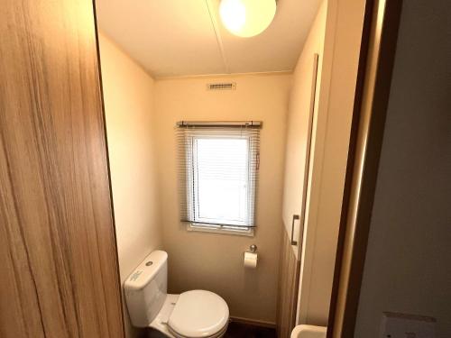 a small bathroom with a toilet and a window at Beach Resort Kamperland - 1152 in Kamperland