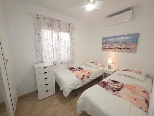 a bedroom with two twin beds and a dresser at La Casa de Torrevieja in Torrevieja
