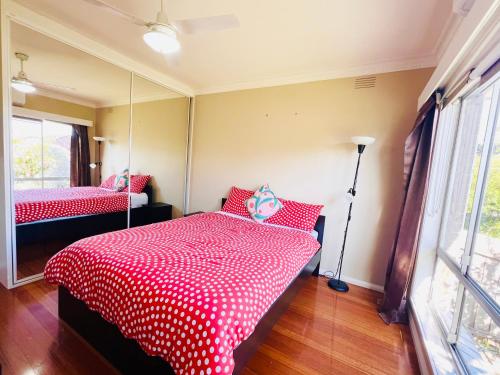 a bedroom with two beds with red and white polka dots at Cozy, quiet private room in Lalor in Lalor