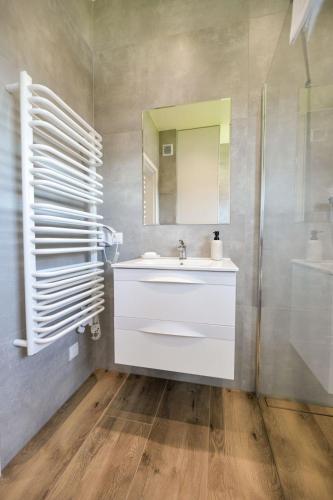 a bathroom with a white sink and a mirror at Sun & Garden View in Oświęcim