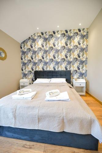 a bedroom with a bed with two towels on it at Sun & Garden View in Oświęcim
