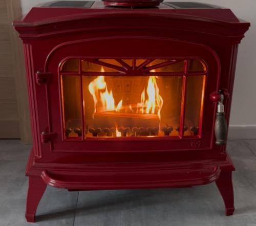 a red stove with a fire in it at niolonlabricotier vue direct sur la mer in Le Rove