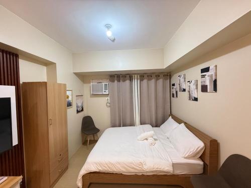 a bedroom with a bed with a towel on it at Oregano Suite- Avida Towers Aspira 2 in Sampong