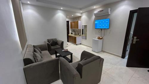 a living room with two couches and a tv at شقق درةراشد للشقق المخدومة in Hafr Al-Batin