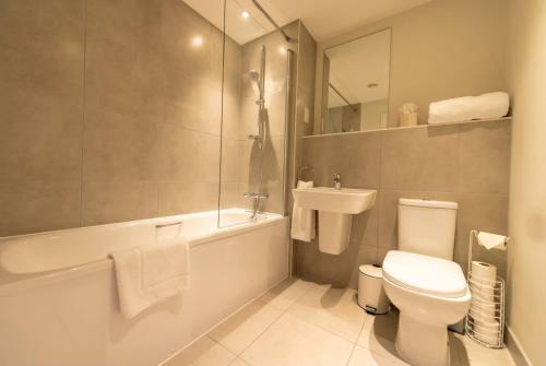 a bathroom with a toilet and a tub and a sink at Fantastic 1 Bed Apartment in Crawley in Crawley