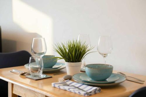 a wooden table with two plates and wine glasses at Fantastic 1 Bed Apartment in Crawley in Crawley
