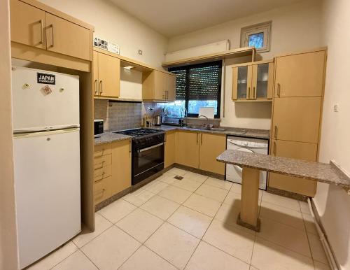 Spacious central apartment في عمّان: مطبخ بخزائن خشبية وثلاجة بيضاء