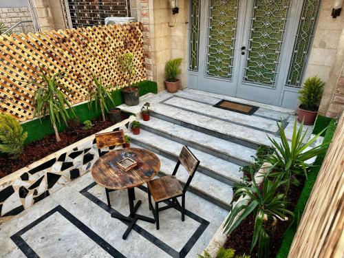 Spacious central apartment في عمّان: فناء به طاولة وكراسي خشبية وباب