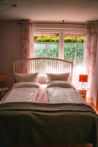 ein Schlafzimmer mit einem großen Bett vor einem Fenster in der Unterkunft Aurora 1 in Wiesmoor