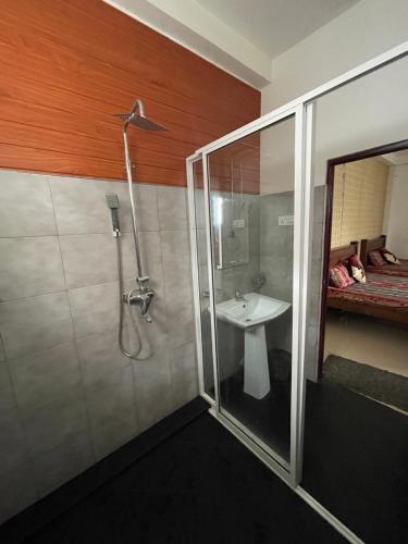 ein Badezimmer mit Dusche und Waschbecken in der Unterkunft OYO KINGS HOTEL in Katunayaka
