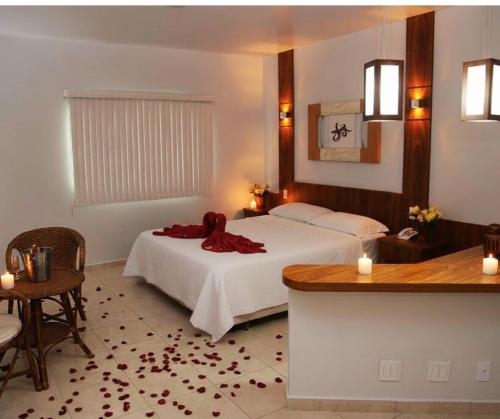 a bedroom with a bed and a table with candles at Monte Castro Executive Hotel in Araguari