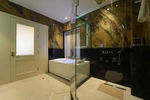 a bathroom with a shower and a sink and a glass door at Hotel Maharaja Palace Rohtak in Kahrāwar