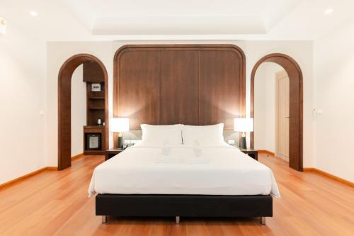 a bedroom with a large white bed with two lamps at Sann Boutique Nan in Nan