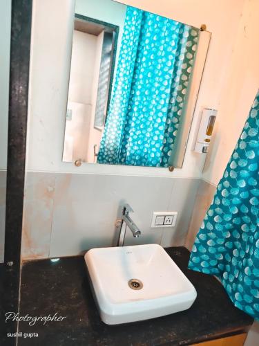 a bathroom with a sink and a mirror at RK Hotel in Boisar