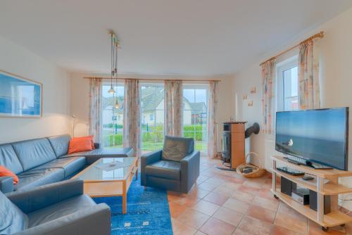 a living room with a couch and a flat screen tv at Strandhaus Thiessow, Wohnung mit 2 Bädern in Thiessow