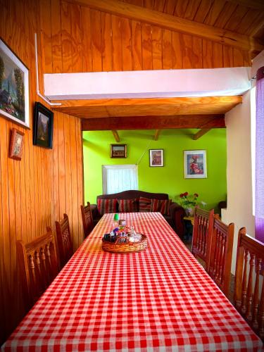 a dining room with a red and white checkered table at Casa De Piedra Le Petit Chalet in San Clemente