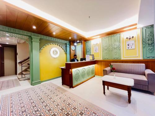 a lobby with a waiting room with a couch and a table at Elegance Inn in Varanasi