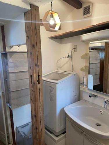 a small bathroom with a washing machine and a sink at イヤシロチomoya in Onomichi