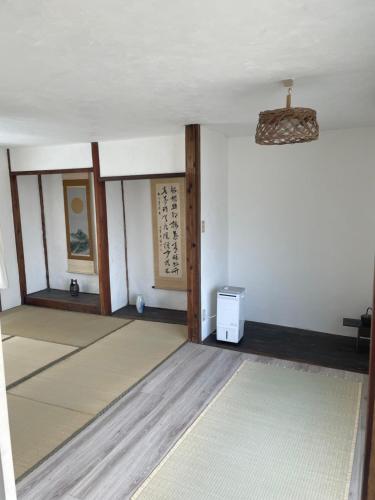 a room with white walls and a ceiling with a fan at イヤシロチomoya in Onomichi