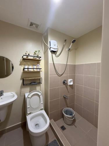 a bathroom with a toilet and a sink and a shower at Oregano Suite- Avida Towers Aspira 2 in Sampong