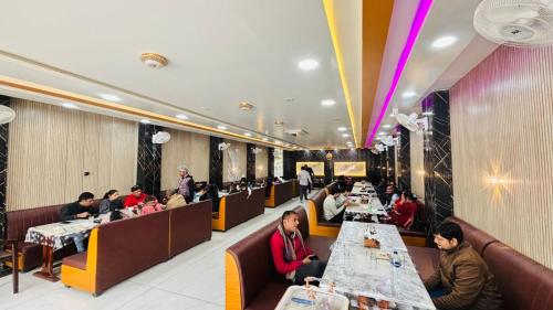 un gruppo di persone sedute ai tavoli di un ristorante di Ananya Hotel and Restaurant Naimisharanya a Naimishāranya