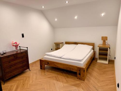 a bedroom with a bed and a wooden dresser at Willa Rytel in Rytel