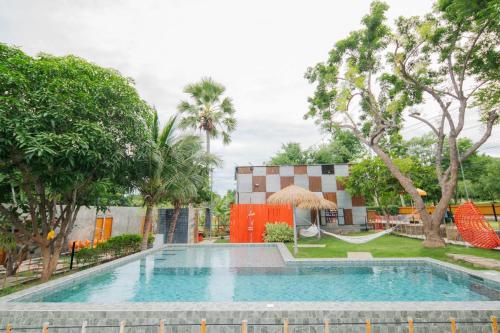 a swimming pool in front of a building with trees at บ้านมะนาวรีสอร์ท เกาะล้าน in Ko Larn