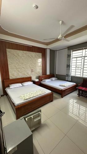 a bedroom with two beds and a ceiling at Khách sạn Nhất Phương 2 in Ấp Ðông An (1)