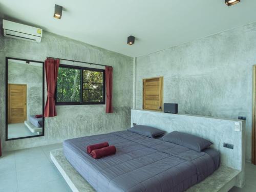 ein Schlafzimmer mit einem großen Bett mit einem roten Kissen darauf in der Unterkunft Eskobar Villa Exclusive in Baan Tai