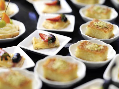 a bunch of small appetizers in white bowls at Mövenpick Resort Petra in Wadi Musa