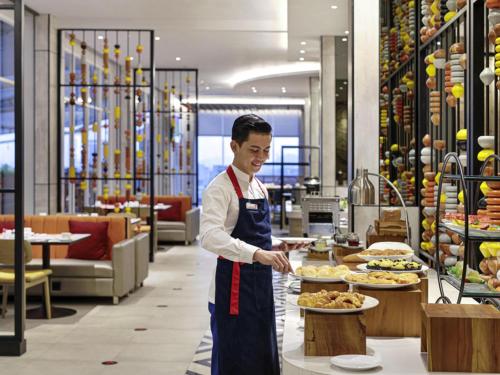 沙马林达Ibis Samarinda的餐馆里做饭的男人