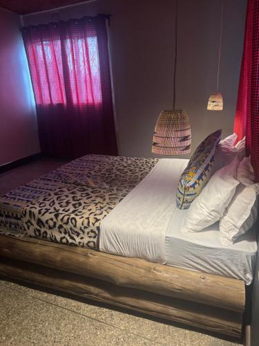 a bedroom with a bed with a cheetah print sheets and pillows at Woodland villa in Arusha