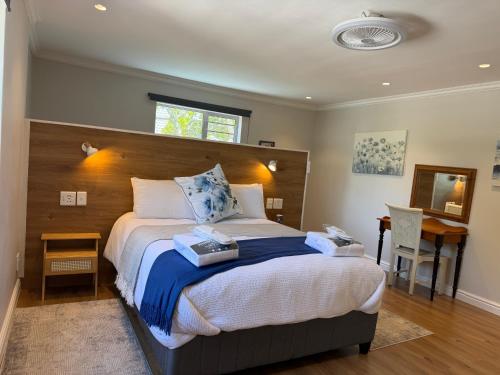 ein Schlafzimmer mit einem großen Bett und einem Schreibtisch in der Unterkunft Ocean Whisper in Plettenberg Bay