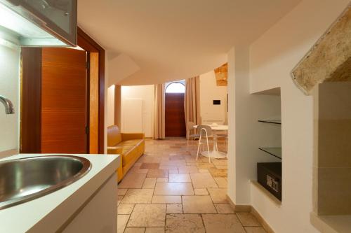 een keuken met een spoelbak en een woonkamer bij Monteforte Suite & Spa in Ugento