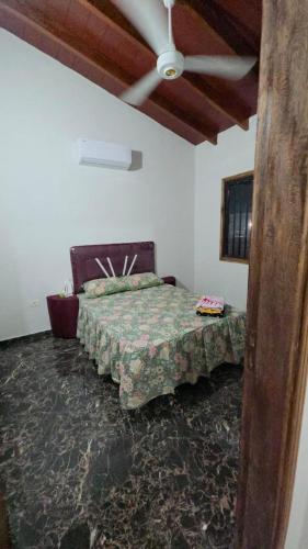 ein Schlafzimmer mit Bett und Deckenventilator in der Unterkunft Casa Quinta Elena in San Lorenzo