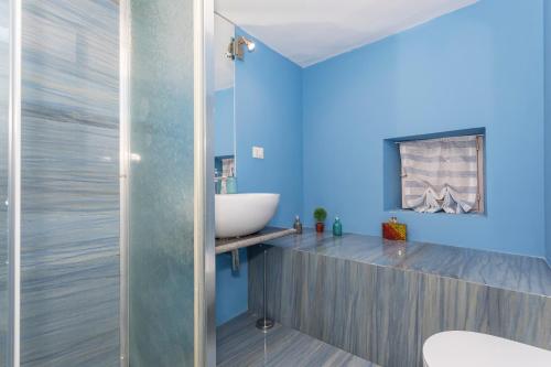 bagno con pareti blu e lavandino di Domus Elisae - Taormina a Taormina