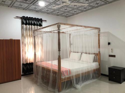 a bedroom with a canopy bed in a room at Calm Garden Cabanas in Tangalle