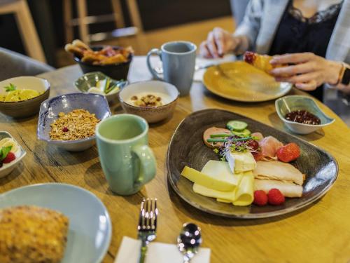 a wooden table with a plate of food on it at ibis Duesseldorf Airport in Düsseldorf