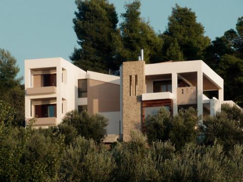 a white house on a hill with trees at Sea Horizon Private Villa with Panoramic Sea Views in Nea Skioni