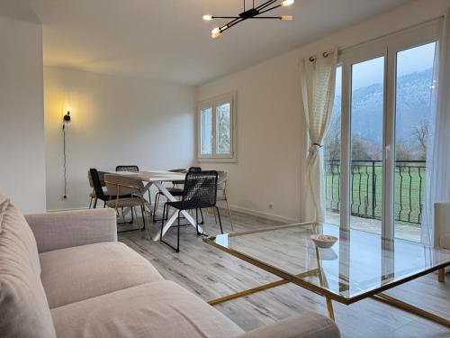 een woonkamer met een bank en een tafel met stoelen bij Maison partagée Bonneville in Bonneville