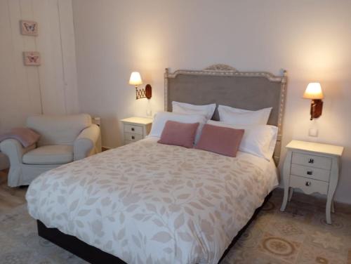 a bedroom with a large bed and a chair at Casa Rural Bellamonte in Belmonte
