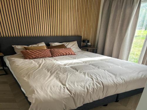 a large bed with white sheets and pillows at Sustainable Stay by Palette Resort de-Steppe in Ulicoten
