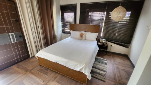 a bedroom with a large bed with white sheets at Beach House at Kokrobite in Kokrobite