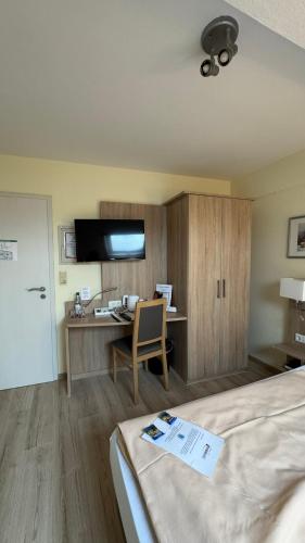 a room with a bed and a desk with a computer at Hotel am Rosenbad in Fulda
