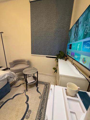 ein Raum mit einer Leinwand, einem Tisch und einem Stuhl in der Unterkunft استديو المعتليه in Riad
