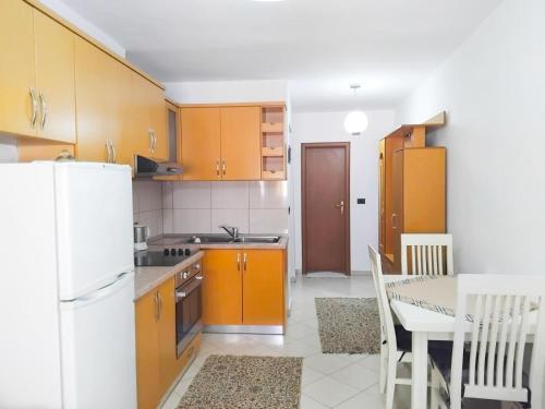 una cucina con un tavolo e un frigorifero bianco di Blin's Apartament a Tirana